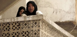 A woman stands in a balcony after hearing shelling in Aleppo